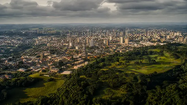 Vista aérea de Ponta Grossa ao entardecer, cercada de áreas verdes (imagem ilustrativa)