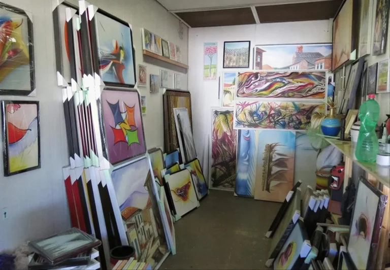 Ateliê com paredes cheias de quadros pintados à mão