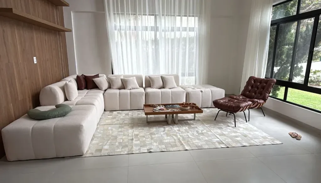 Tapete de couro costurado em patchwork claro na sala com sofá modular