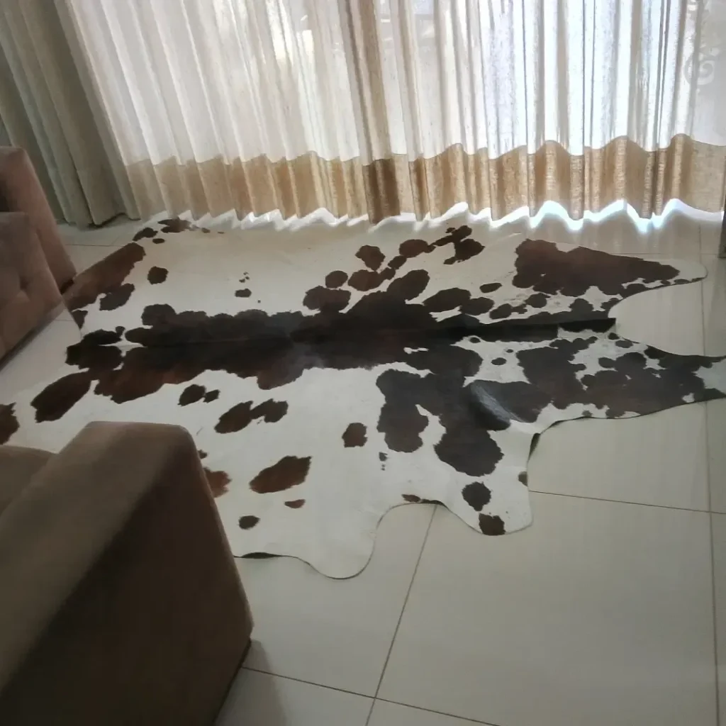Tapete de couro de boi inteiro preto e branco malhado sobre piso claro
