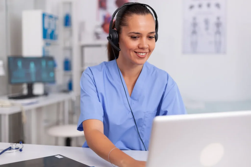 Profissional de saúde com headset organizando a agenda de exames no computador