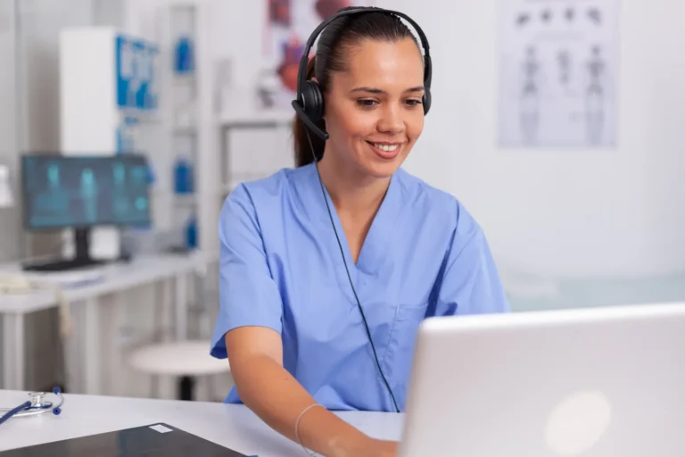 Profissional de saúde com headset organizando a agenda de exames no computador