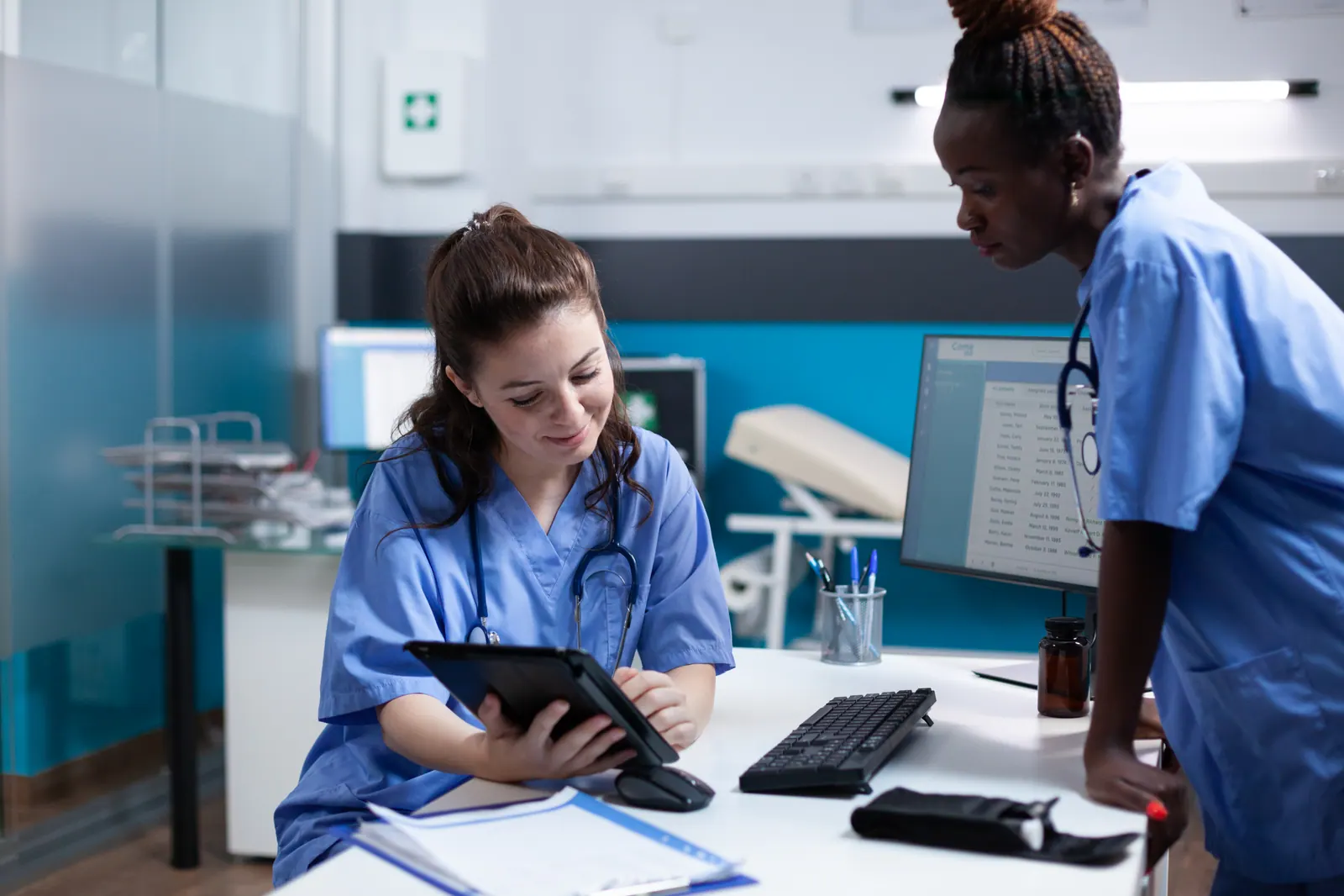 Equipe de enfermagem consultando dados do paciente no tablet