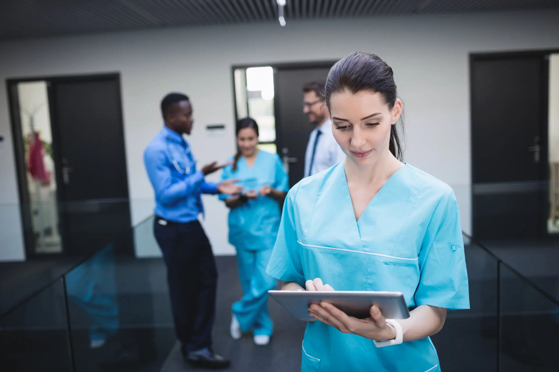 Enfermeira usando tablet no corredor de um hospital moderno