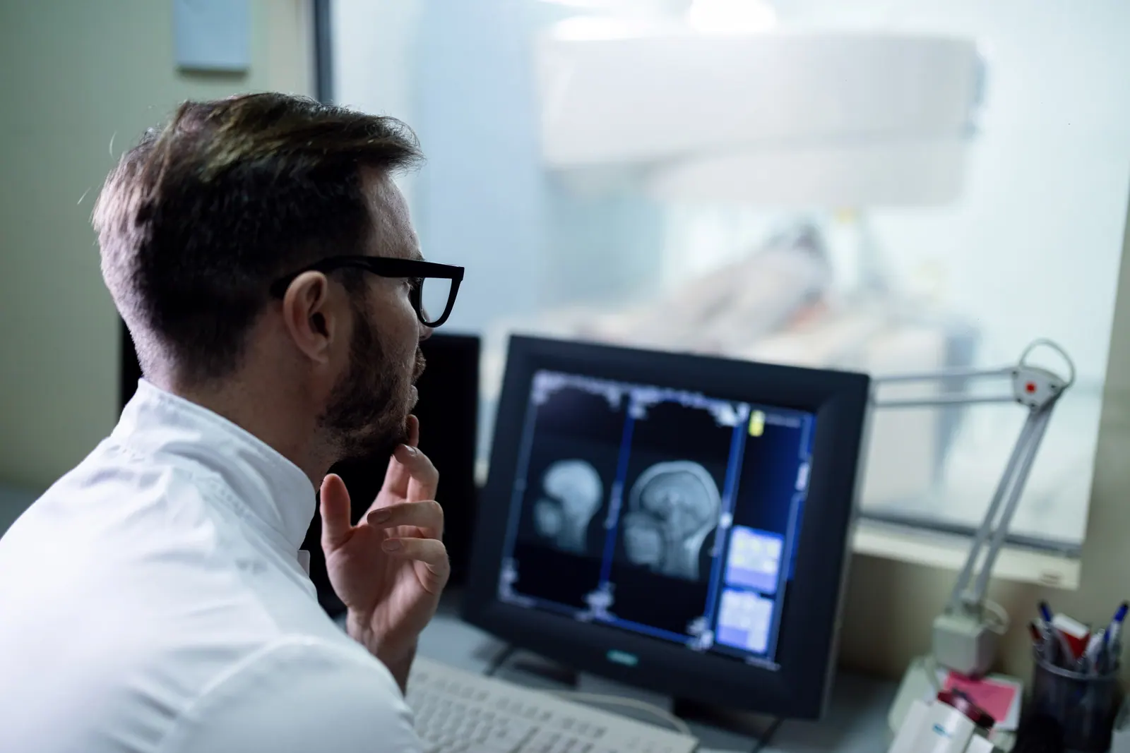 Médico analisando imagens de ressonância no monitor para elaborar o laudo
