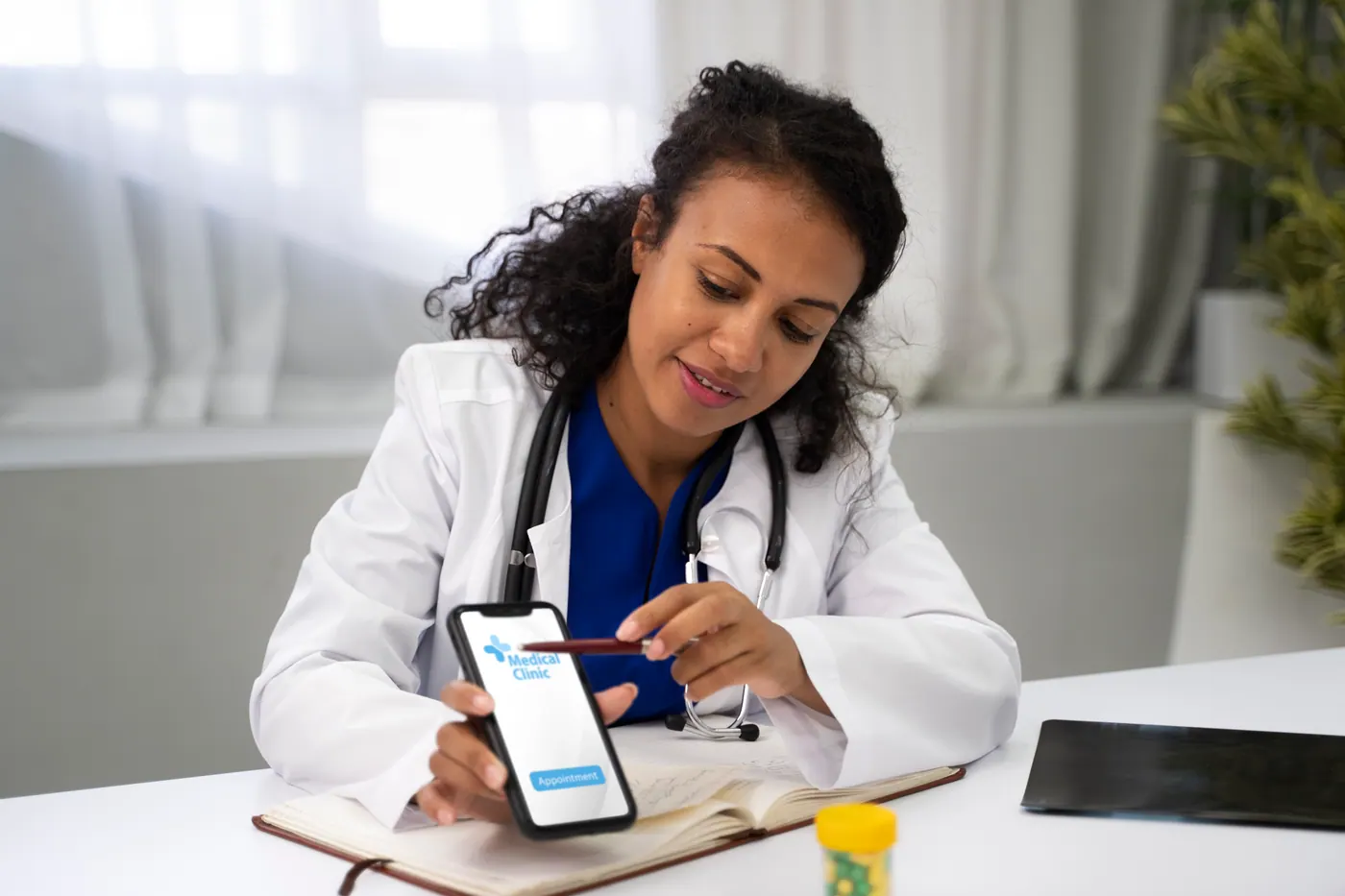 Médica usando aplicativo de saúde no celular durante o atendimento