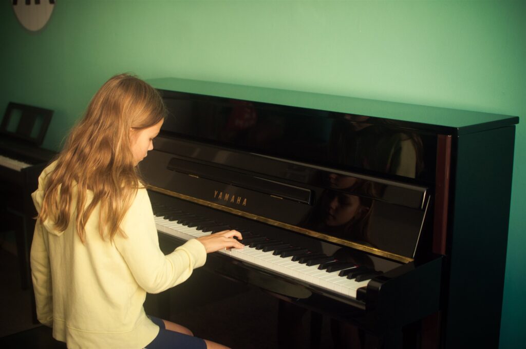 Aluna ao piano na sala do studio