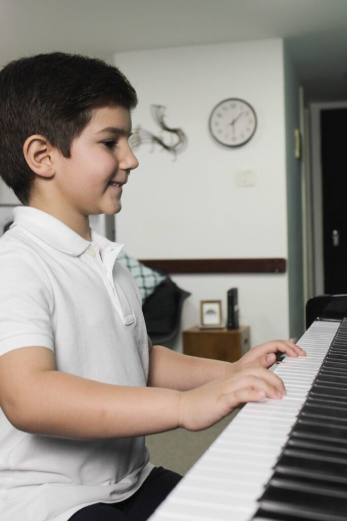 Aluno infantil em aula de piano
