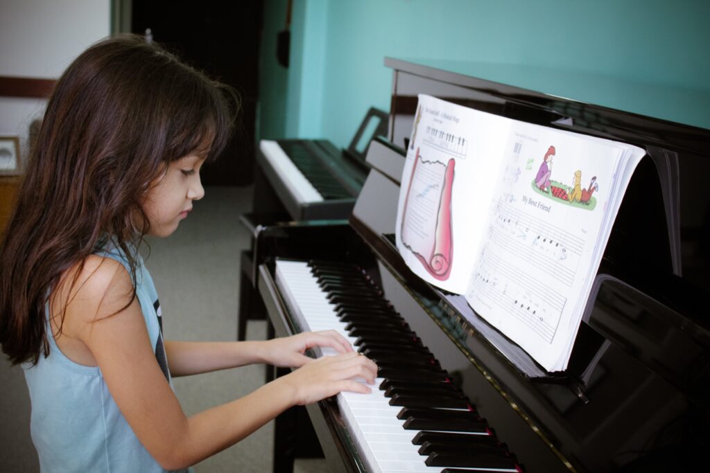Aluna tocando piano com partitura ilustrada