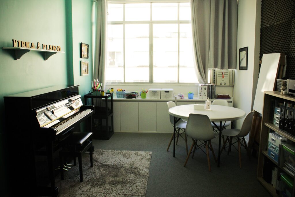 Sala do studio com luz natural e piano vertical