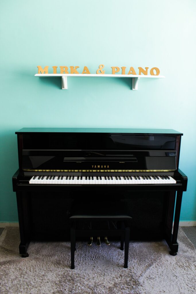 Piano vertical Yamaha do studio sob a marca na parede