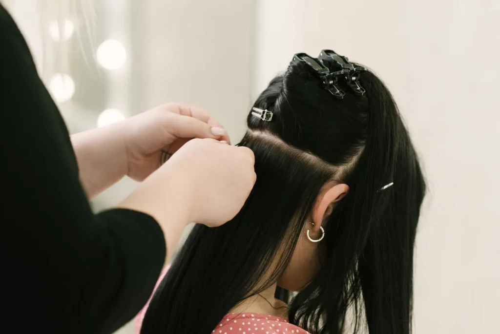 Especialista aplicando Mega Hair em cabelo escuro