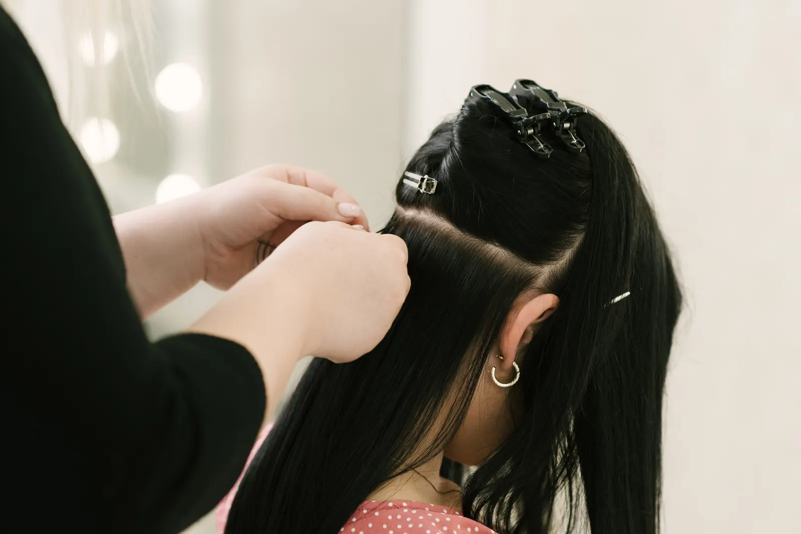 Especialista aplicando Mega Hair em cabelo escuro