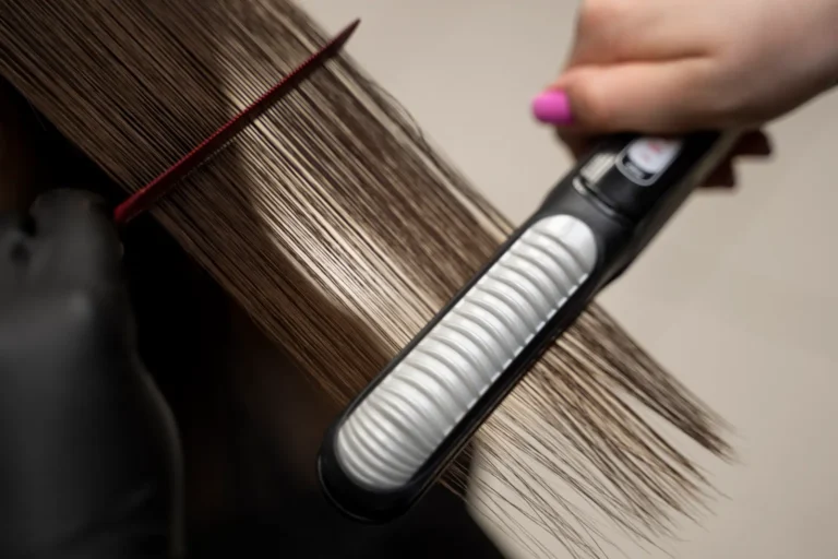 Prancha alisando mecha de cabelo durante a progressiva