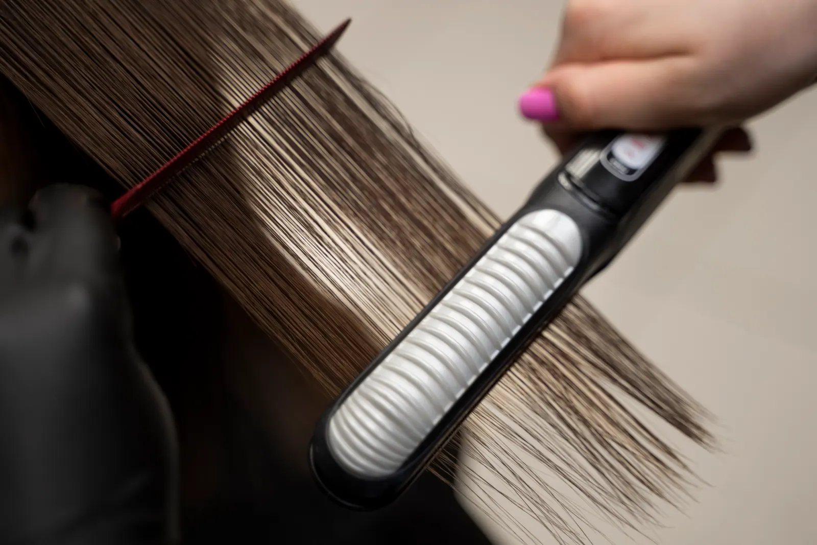 Prancha alisando mecha de cabelo durante a progressiva