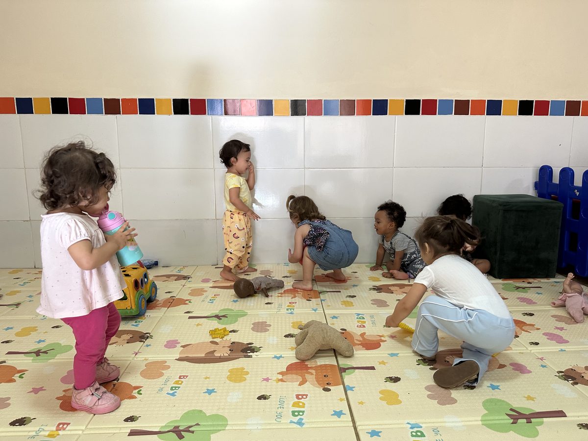 Crianças pequenas brincando sobre o tatame
