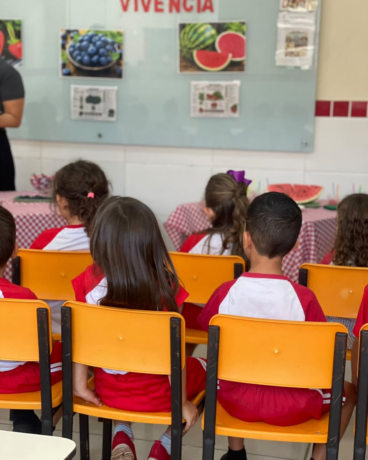 Crianças da Via Cæli em atividade de sala, de uniforme vermelho e branco