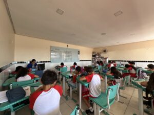 Alunos do Fundamental I nas carteiras, com a professora ao fundo