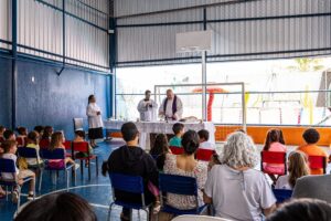 Pais e alunos na primeira reunião de pais, no pátio coberto da escola