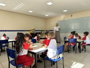 Professora mostra uma atividade às crianças da Pré-escola