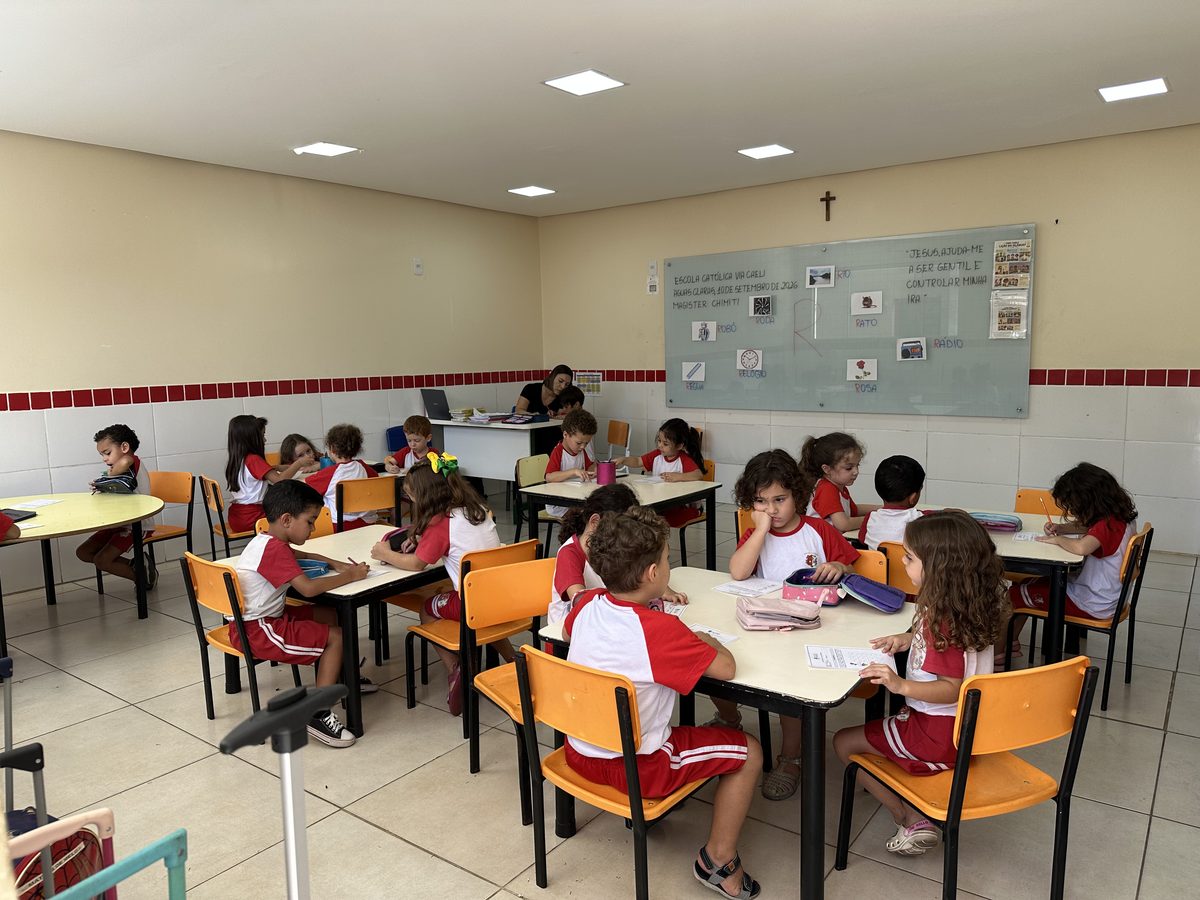 Crianças em atividade nas mesas coletivas da sala